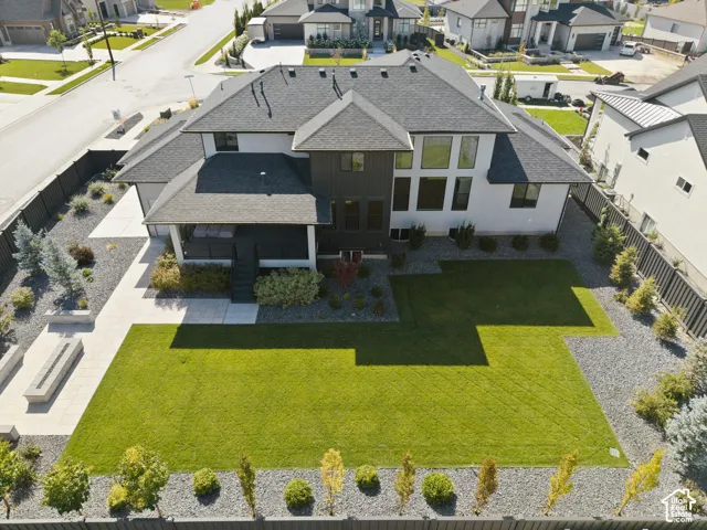 Expansive backyard featuring a manicured lawn, gravel landscaping, and mature plantings