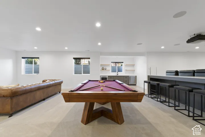 Open-concept entertainment space with recessed lighting and two egress windows