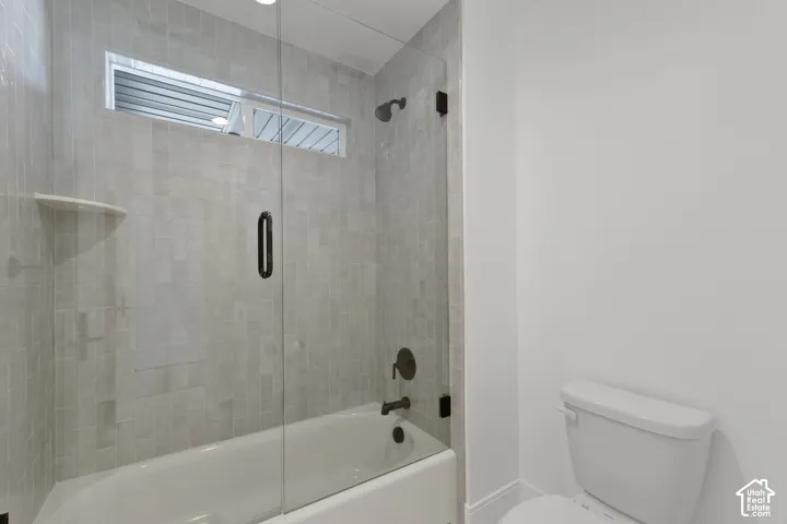 Bathtub with full-height tile surround, clear glass shower enclosure, and transom window
