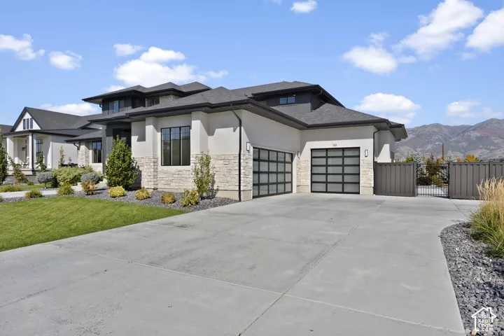 Contemporary stucco and stone exterior with a multi-level roofline