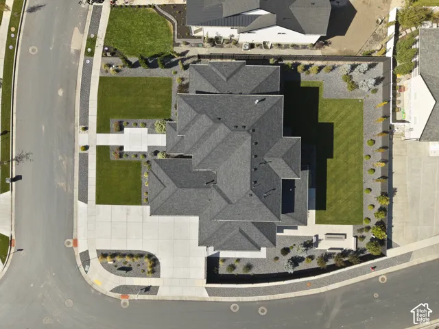 Pitched roofline, concrete driveway, concrete walkways, manicured lawns, and low-maintenance landscaping