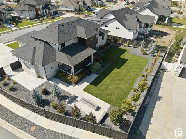 Contemporary multi-story residence featuring a dark shingle roof, white and dark siding, and a stone facade