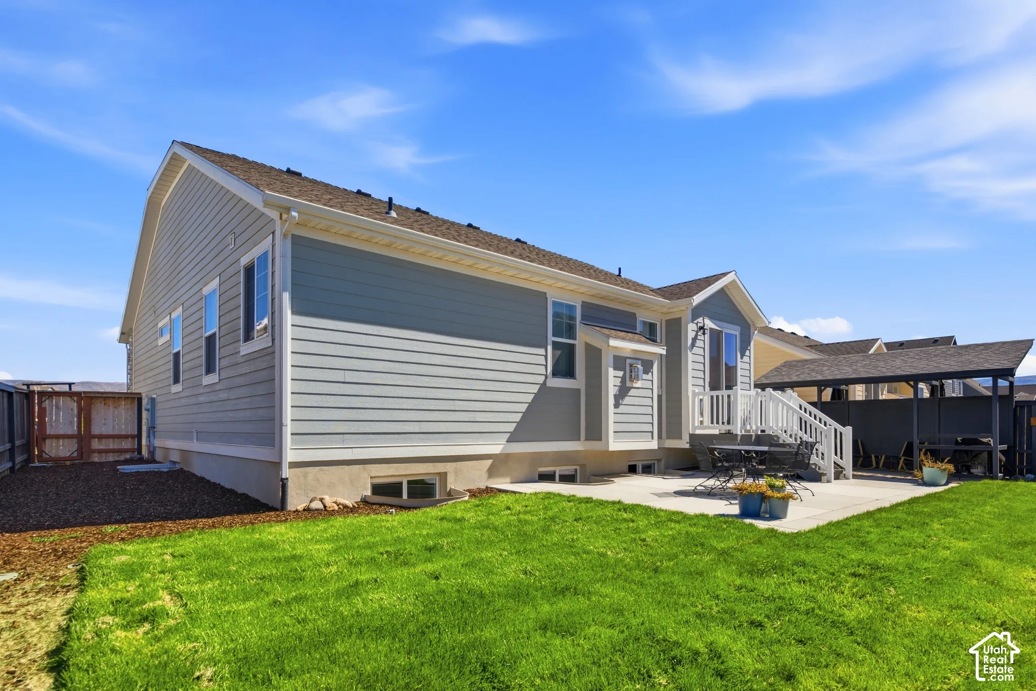 Modern farmhouse residence showcasing vinyl siding with board-and-batten accents, peaked roofline with architectural shingles, and a covered front porch with decorative railings