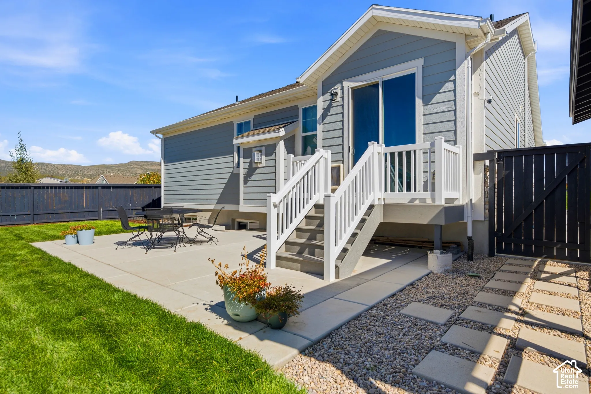 Expansive backyard with a manicured lawn, concrete patio, and privacy fencing