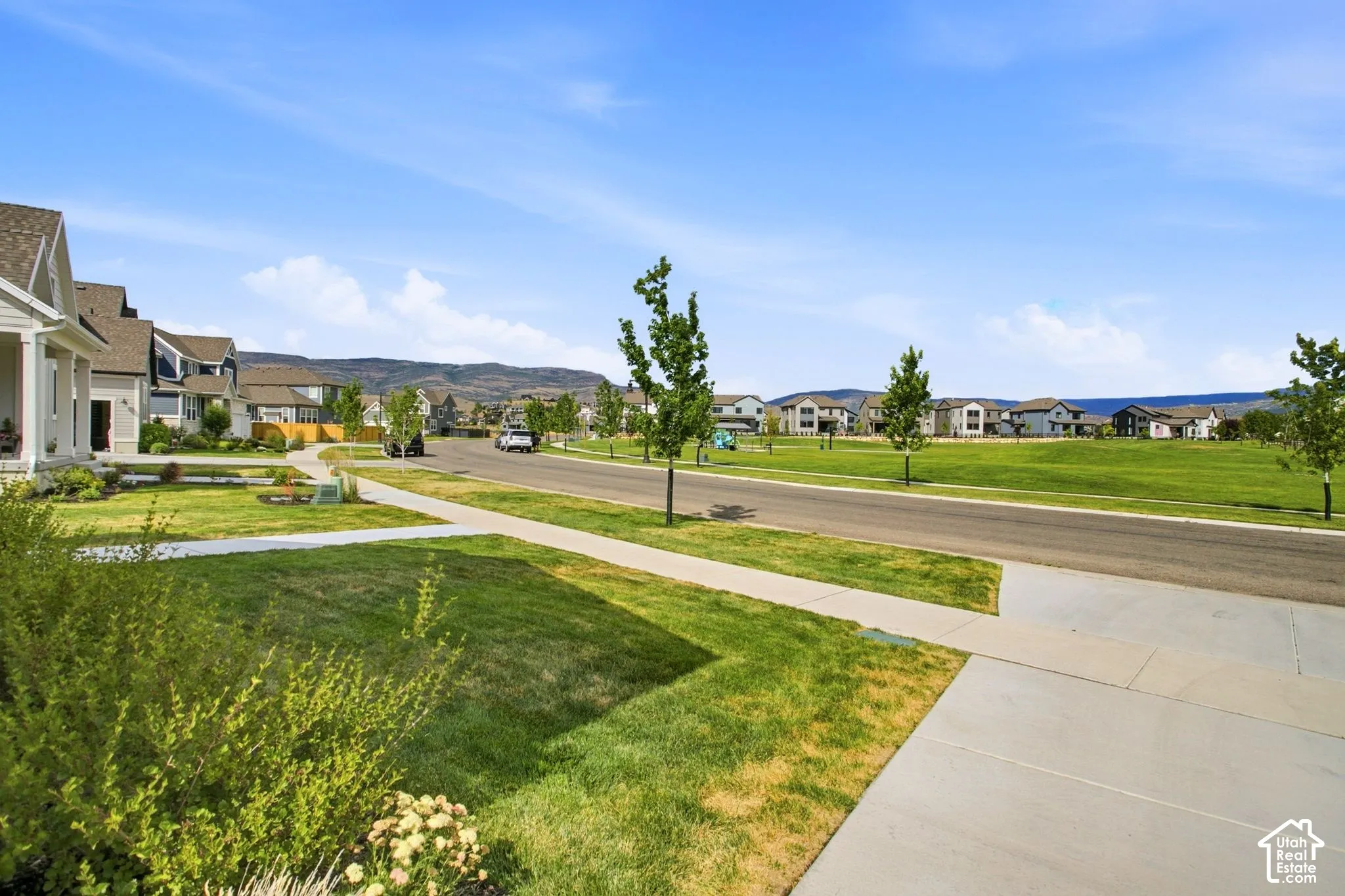 Expansive green space and a paved street with sidewalks