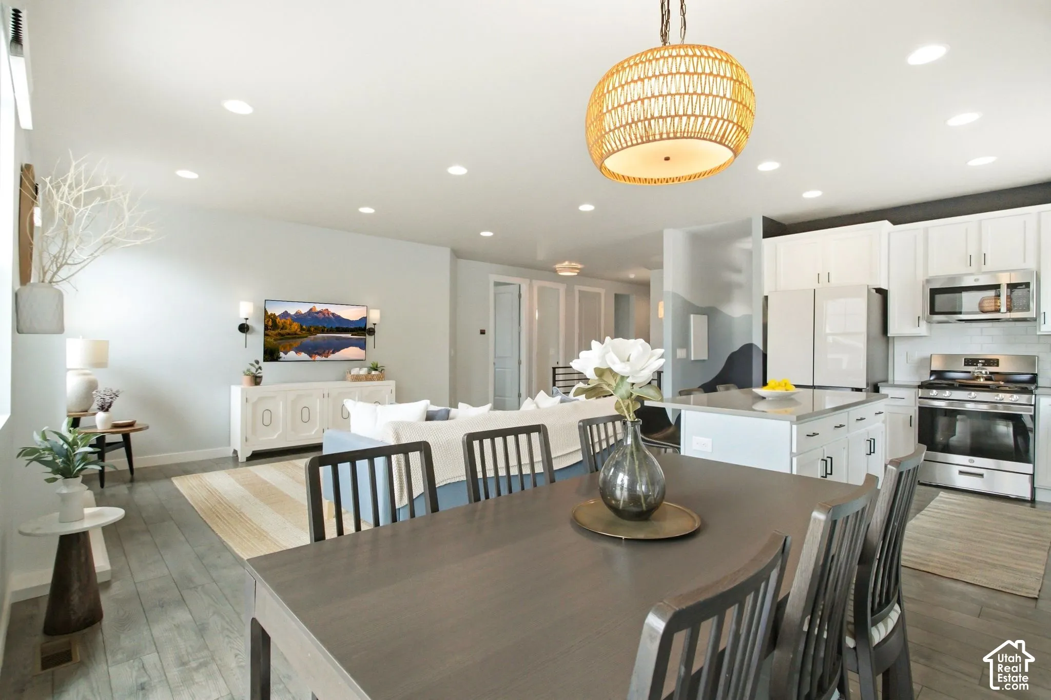 Open-concept layout with wood-finish flooring, recessed lighting, and a woven pendant light fixture