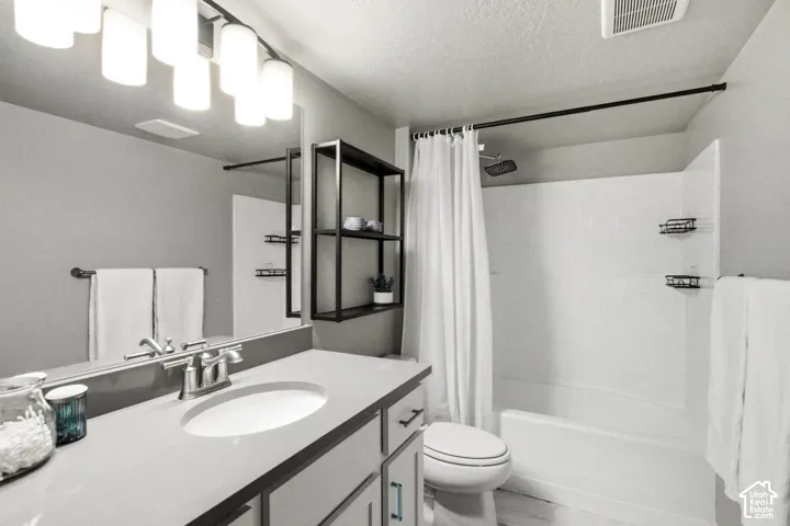 Modern bathroom featuring a floating vanity with rectangular vessel sink, quartz countertop, and chrome faucet fixtures