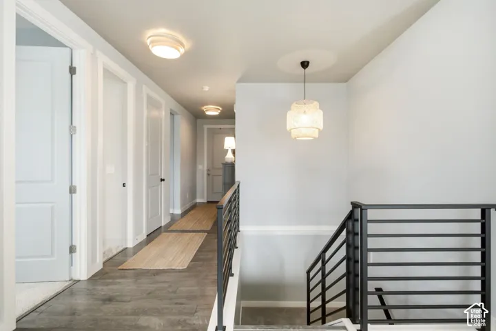Wood-finish flooring with a modern staircase featuring black metal railings