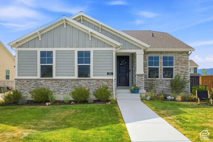 Modern ranch-style home featuring a mixed-material exterior with horizontal fiber cement siding and stone veneer base