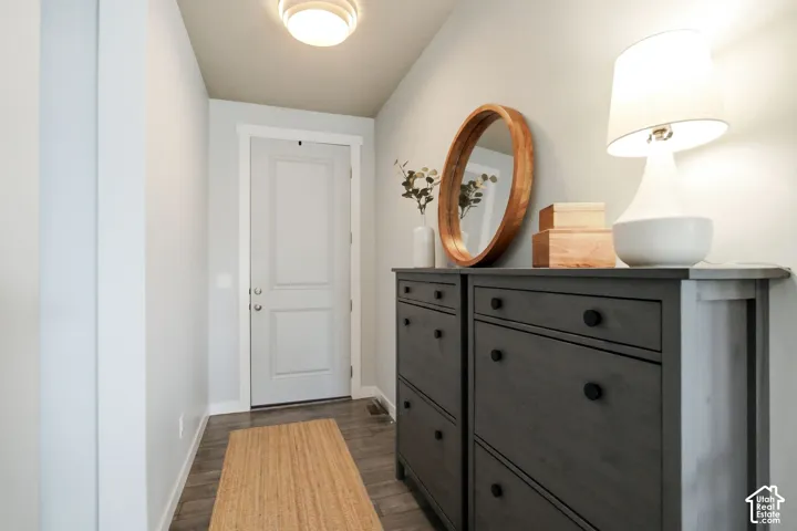 Panel entry door with white trim, wood-finish flooring, and flush-mount ceiling lighting