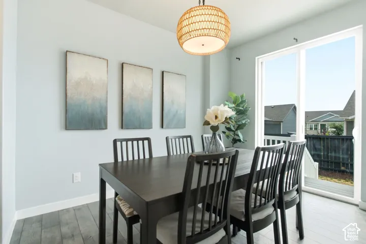 Wood-finish flooring, a woven pendant light fixture, and a sliding glass door providing outdoor access