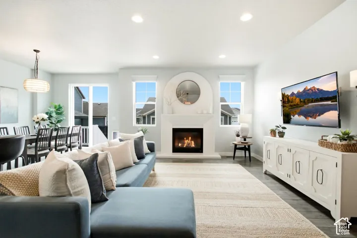 Open-concept living space with a fireplace, recessed lighting, and wood-finish flooring