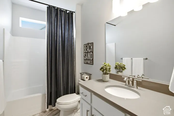 Modern vanity with an integrated sink and brushed nickel faucet, full-width mirror, and a white bathtub with an overhead window
