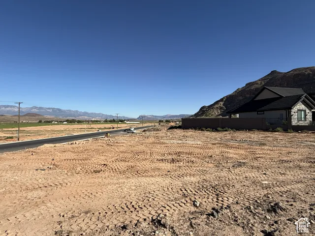 Expansive cleared lot with mountain backdrop and paved road frontage