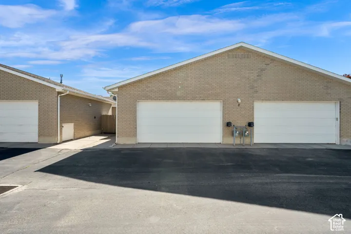Attached two-car garage featuring two individual bay doors and brick exterior
