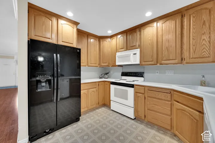 U-shaped kitchen featuring wood cabinetry, white countertops, built-in microwave, and recessed lighting