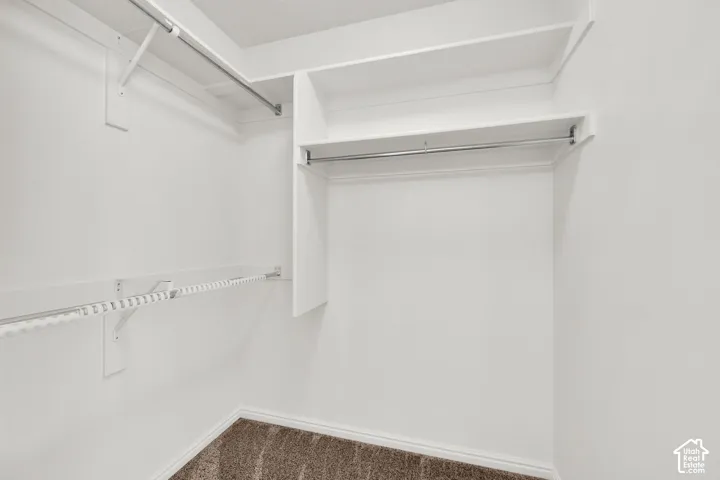 Master WIC. White with multiple shelving units and hanging rods