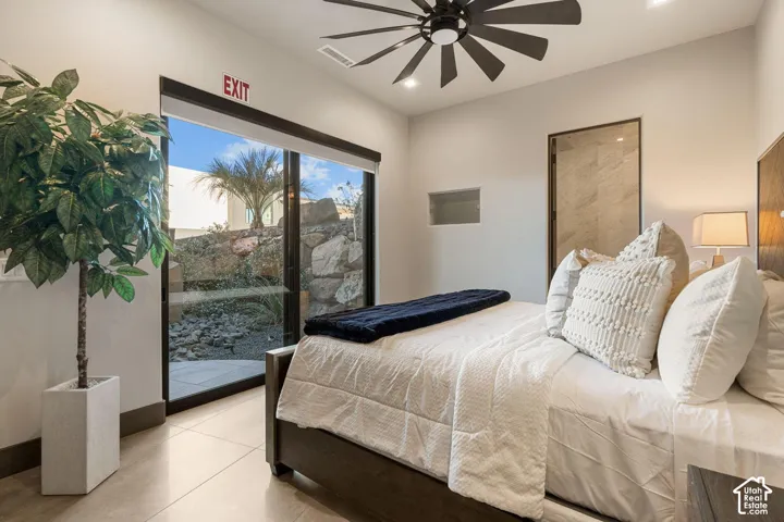 Expansive glass sliding door, large ceiling fan with integrated lighting, recessed wall niche, and tile-finish flooring