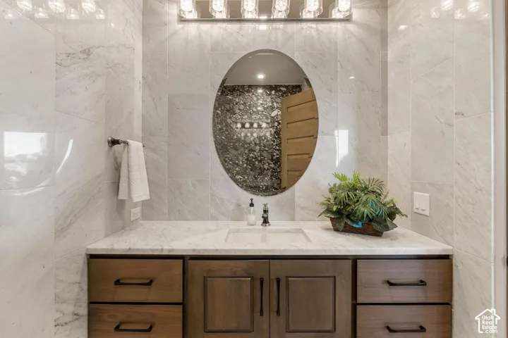 Vanity with a light wood-finish cabinet, integrated sink, and white countertop