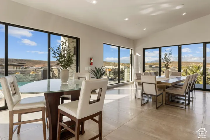 Expansive glass doors and windows, recessed ceiling lighting, and large format floor tiling