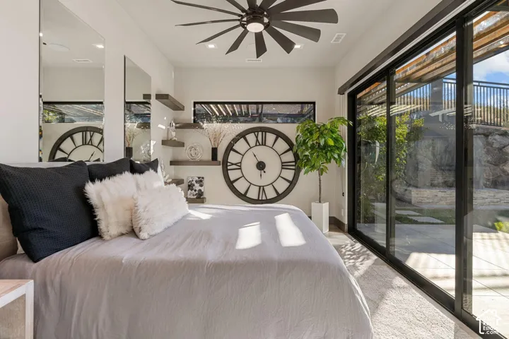 Expansive sliding glass doors, contemporary ceiling fan, mirrored wall panels, built-in floating shelves, and recessed ceiling lighting