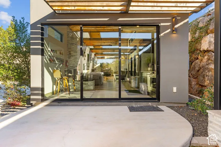 Expansive glass sliding doors open to a concrete patio