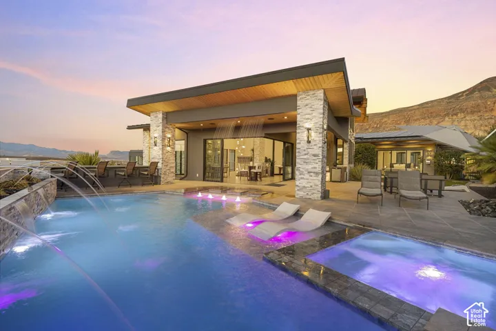 Modern exterior architecture featuring a flat roofline, stacked stone accents, and expansive glass doors