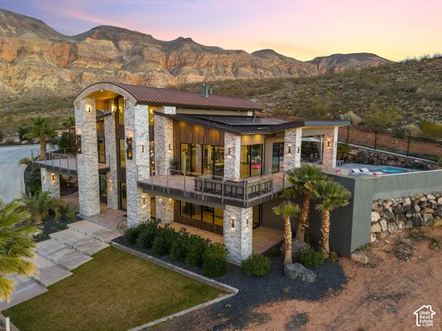 Contemporary exterior with stacked stone accents, multiple balconies, a flat roofline, and an integrated swimming pool