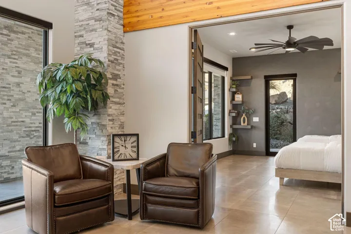 Stone veneer accent wall, wood ceiling accent, large format tile flooring, black frame glass door, integrated wall shelving