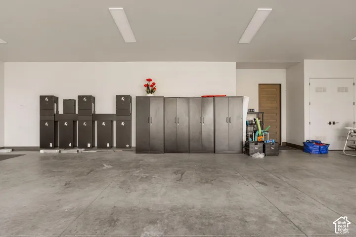 Concrete flooring with white walls and overhead lighting