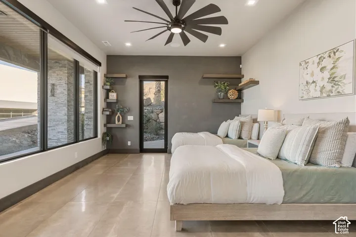 Expansive windows and glass door, contemporary ceiling fan, recessed lighting, and wall-mounted shelving