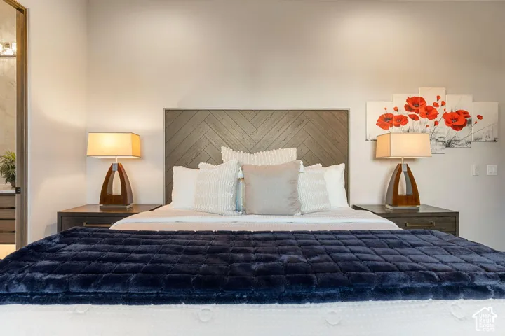 Wood-finish headboard with a herringbone pattern, integrated wall lighting, and recessed ceiling lighting