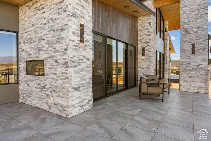 Expansive outdoor patio featuring large format tile flooring and a built-in outdoor fireplace