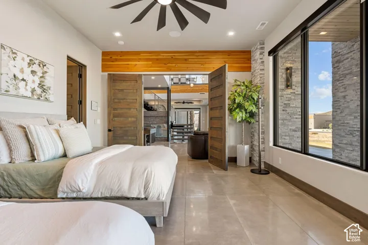Full-height windows, wood-finish interior doors, recessed lighting, wood-finish ceiling beam, and gray tile flooring