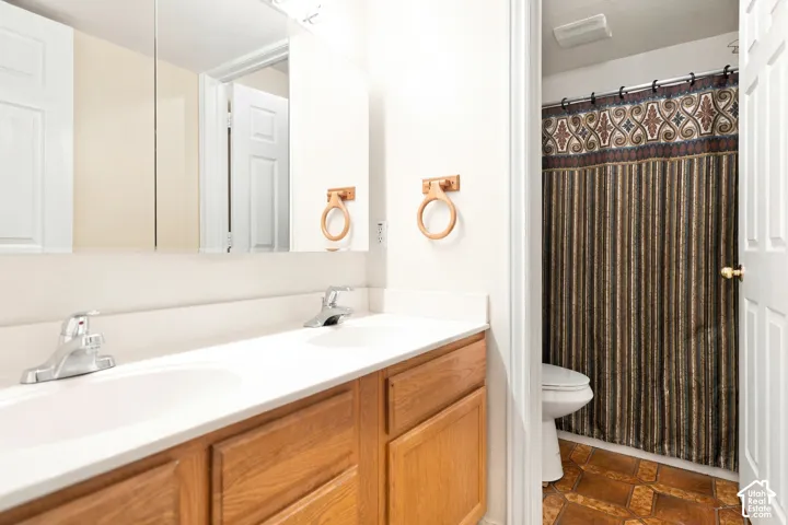 Double vanity with integrated sinks, chrome faucets, and wood-finish cabinetry