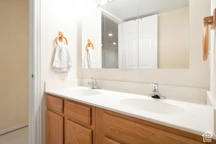 Spa-inspired bathroom vanity featuring dual sinks, wood-finish cabinetry with multiple storage drawers, and a white quartz countertop