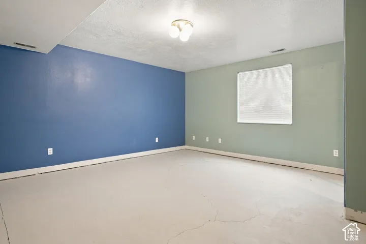 Distinguished room featuring a window with blinds, ceiling-mounted light fixture, and painted walls