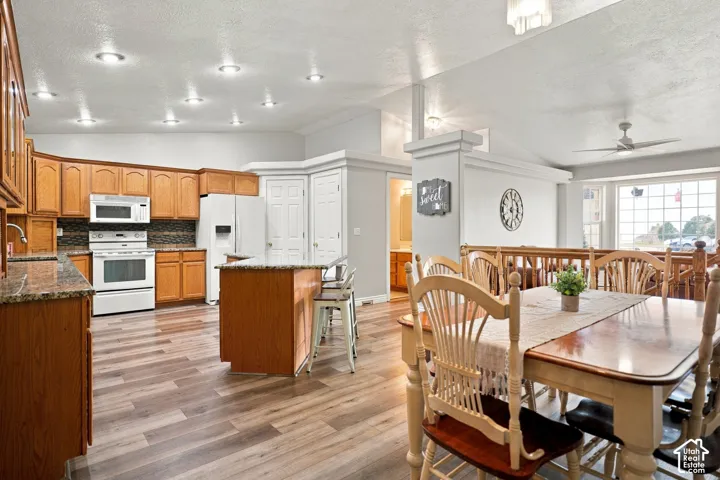 Open concept kitchen and dining area featuring wood-finish flooring, recessed lighting, and a ceiling fan