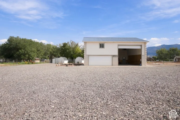 Two-story outbuilding with a metal roof, two garage doors, and a window