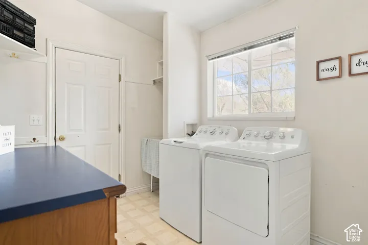 Functional laundry area with a wide window, built-in shelving, and a wood-finish cabinet with a blue countertop