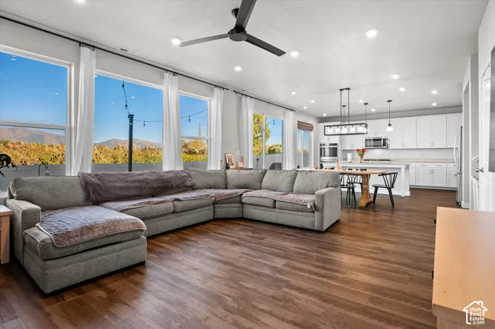 Open-concept living space featuring wood-finish flooring, recessed lighting, and large windows