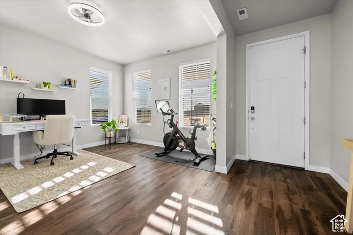 Entryway with wood-finish flooring, a white paneled door, and smart lock hardware