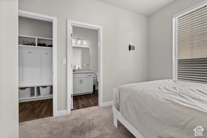 Built-in mudroom style shelving, wood-finish flooring, and a window with blinds