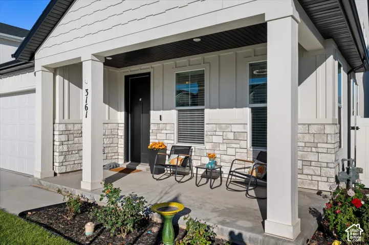 Covered front porch with stone veneer accent and vertical siding