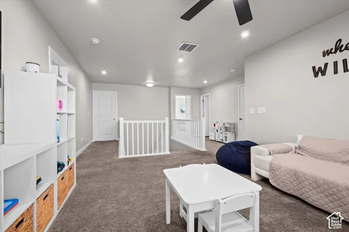 Carpeted living space with recessed lighting and a ceiling fan