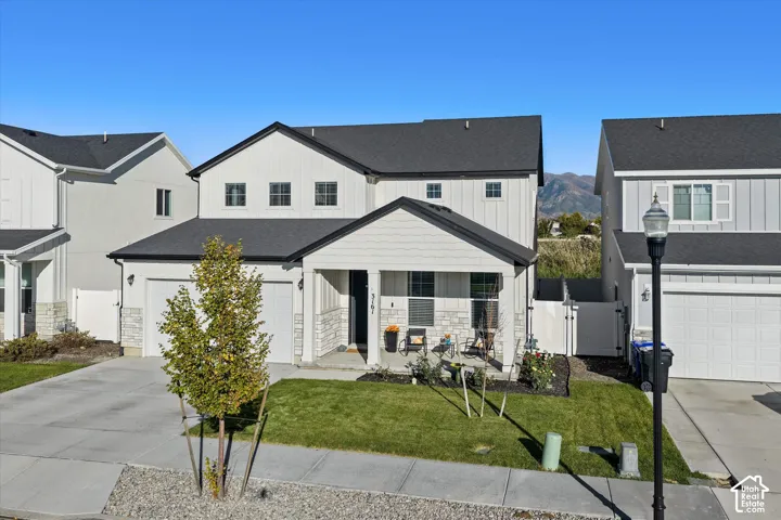 White board-and-batten and horizontal siding exterior with stone accents
