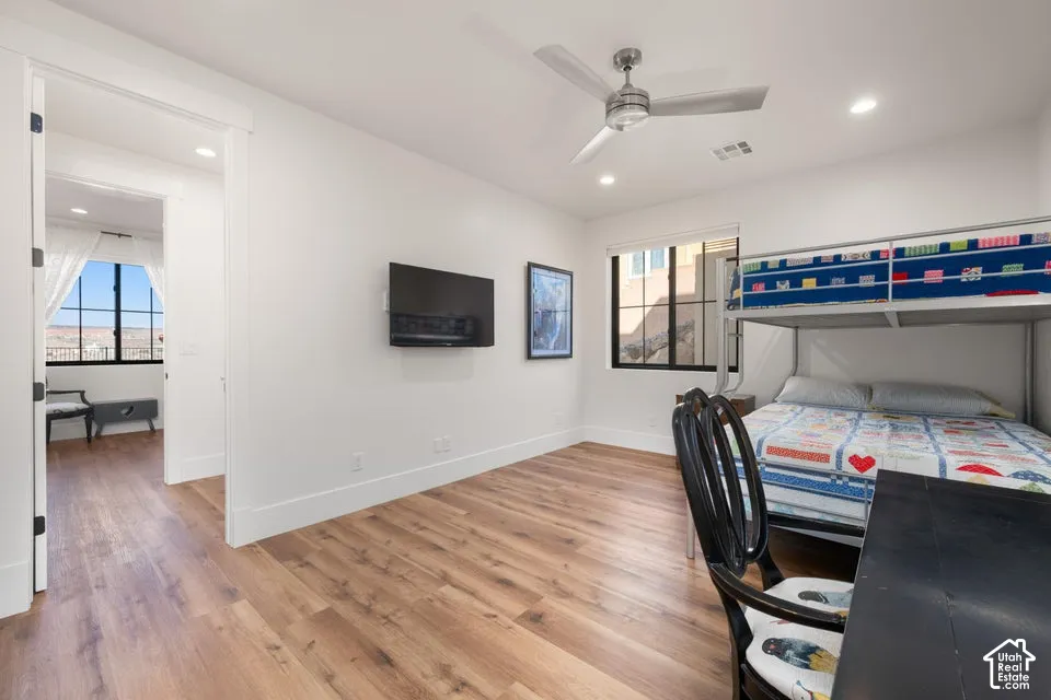 Wood-finish flooring throughout, recessed lighting, ceiling fan, and a built-in wall-mounted television