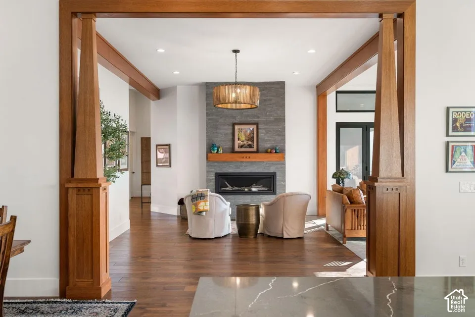 Rich wood-finish architectural elements, stone-clad fireplace, built-in electric fireplace, wood-finish flooring, and recessed lighting