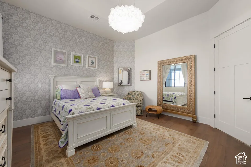 Recessed ceiling light, decorative wallpaper, wood-finish flooring, and white interior door