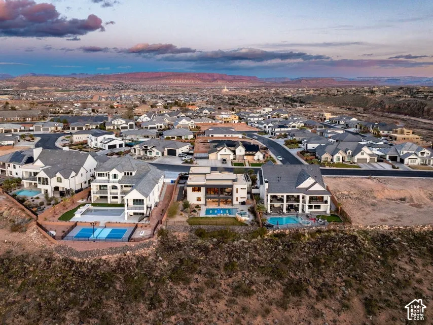 Expansive residential development featuring multiple properties, mature landscaping, and an outdoor recreational court